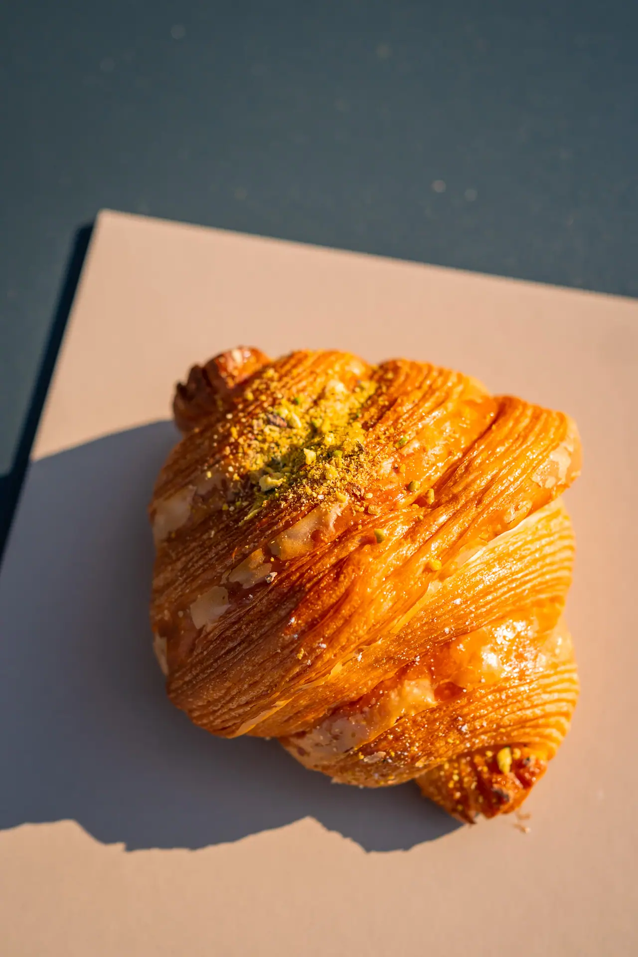 Cornetto al pistacchio su un cartoncino, luce radente