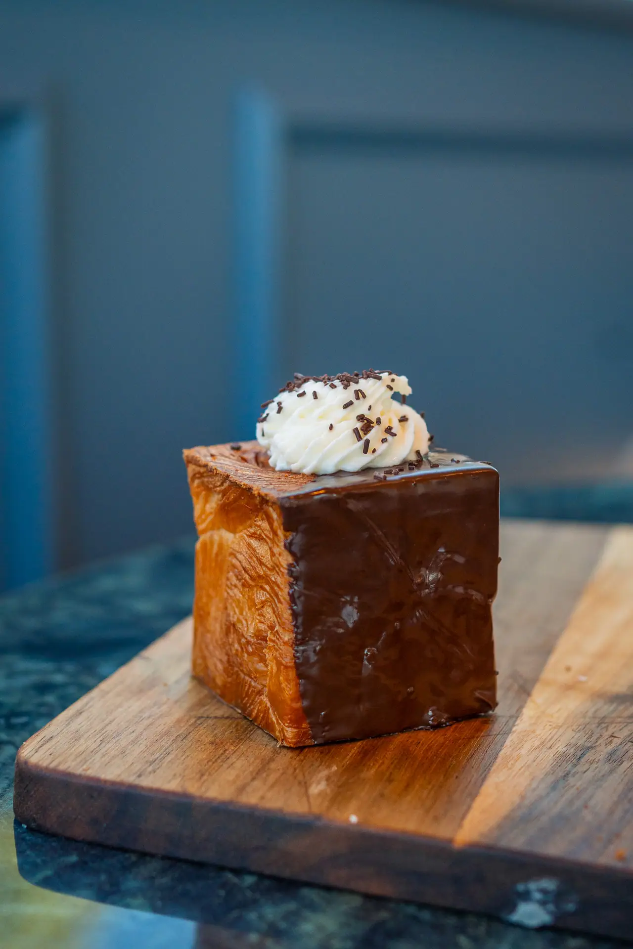 Cubo sfogliato con panna e cacao su un tagliere di legno