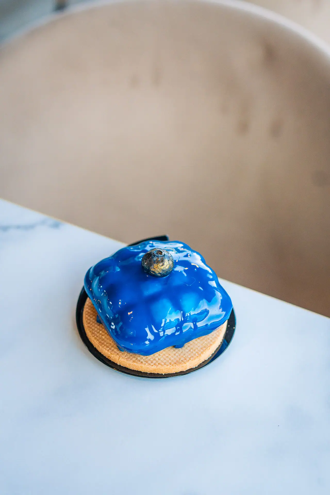 Monoporzione con glassa blu lucida sul marmo